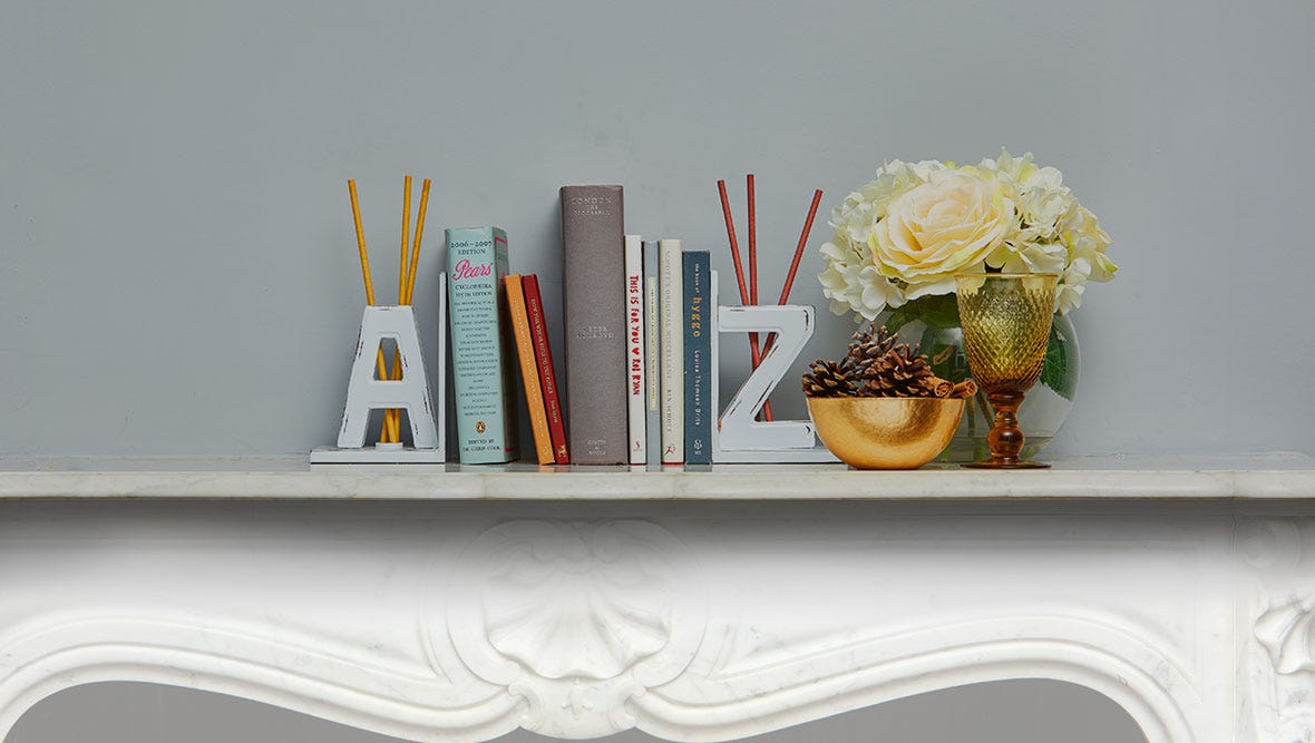Books on a shelf between A and Z bookend fragrance stick holders with SmartScents Fragrance Sticks.